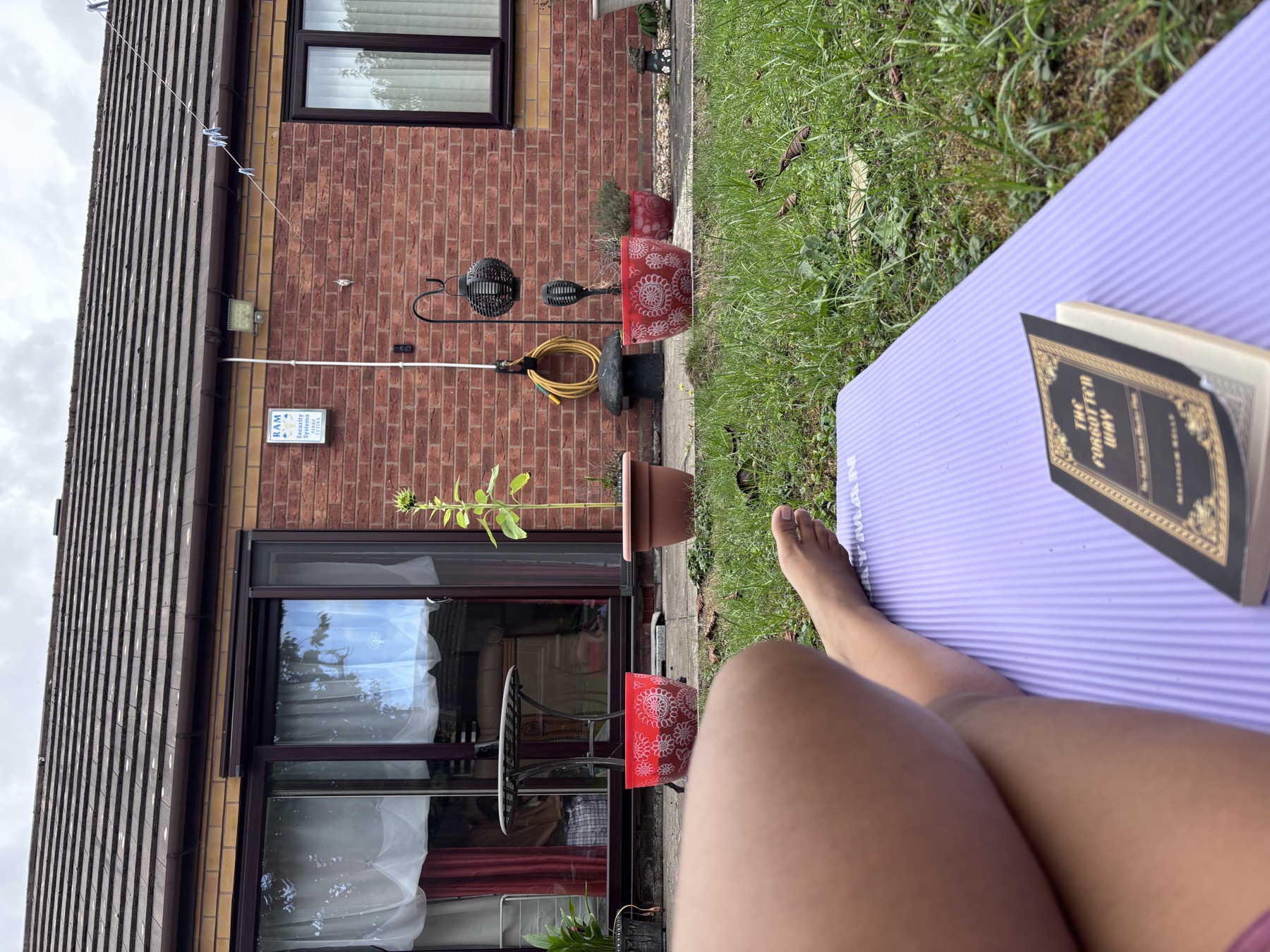 A journal and book resting on a mat in a quiet garden