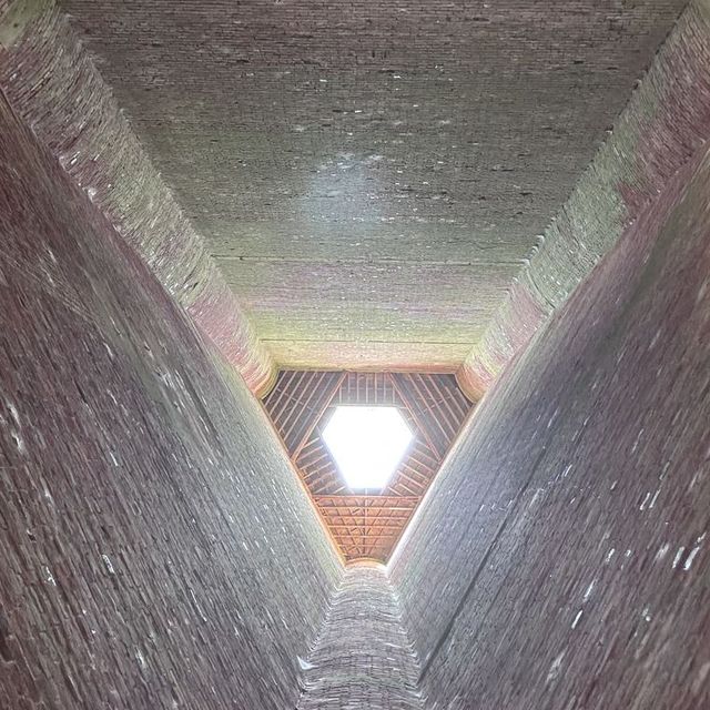 Light entering through an opening high above weathered brick walls